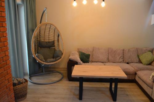 a living room with a couch and a hanging chair at Leśny Zakątek Kownatki 42 in Kozłowo