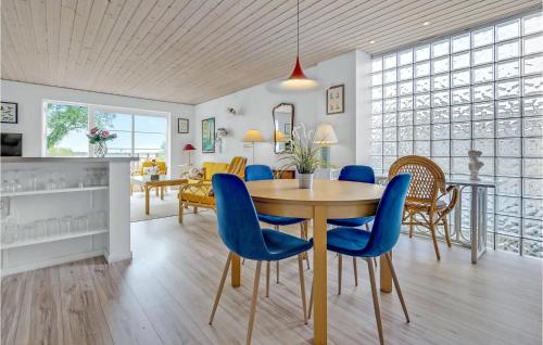a dining room with a table and blue chairs at Two-Bedroom Apartment Stege 0 03 in Stege