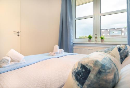 a bedroom with a bed with feet up on the bed at Apartment Meerblick-Balkon-Strand-Golf-TV-Stilvoll in Eckernförde