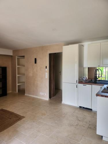 une cuisine vide avec des placards blancs et un comptoir dans l'établissement Grand logement tout confort pour 4 personnes dans une résidence de haut standing, à Saint-Tropez