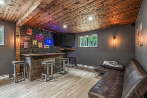 een woonkamer met een bank en een bar bij Natur Rustik - En pleine nature avec Spa in Petite-Rivière-Saint-François
