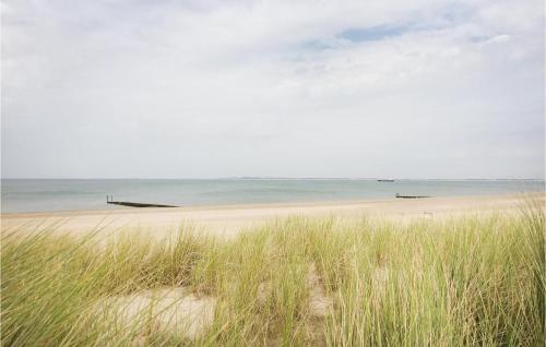 a beach with tall grass in front of the ocean at 2 Bedroom Amazing Home In Groede in Groede