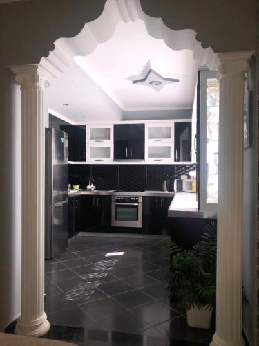 Una cocina con gabinetes negros y un techo blanco. en White Villa, en Sarandë
