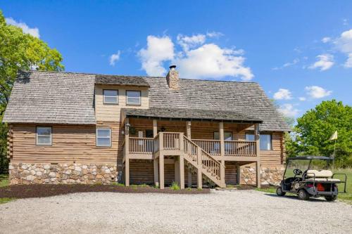 ブランソンにある216 Ridge Laneのゴルフカートが前に置かれた大きな丸太小屋