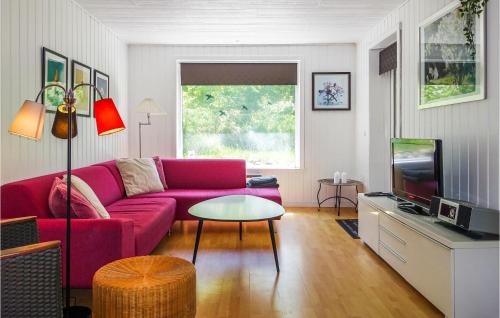 a living room with a red couch and a tv at 3 Bedroom Lovely Home In Rønne in Rønne