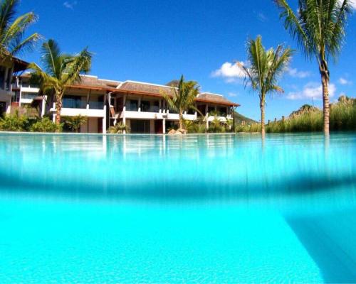 a resort with a large pool of blue water at Au cœur de Tamarin entre Rivière et Mer -Magnifique appartement 3 chambres- Calme et nature in Tamarin