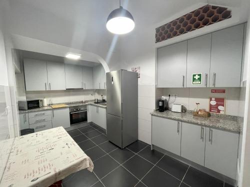 a kitchen with white cabinets and a stainless steel refrigerator at Living Luzia in Santa Luzia
