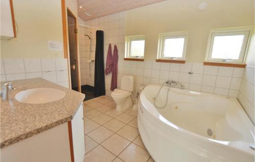 a bathroom with a tub and a toilet and a sink at Holiday Home Strandparken Dnmk Ii in Otterup