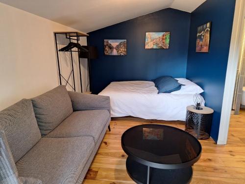 un salon avec un canapé et un lit dans l'établissement Chalet dans jardin privatif, à Caen