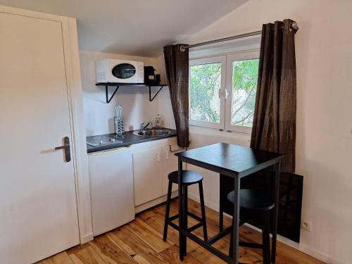 une petite cuisine avec une table et un évier dans l'établissement Chalet dans jardin privatif, à Caen