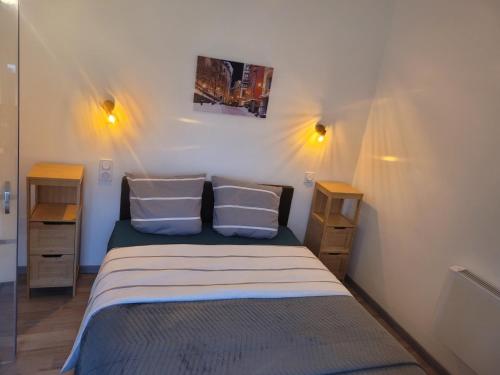 une petite chambre avec un lit et deux tables de nuit dans l'établissement Maison de village, à Bassan