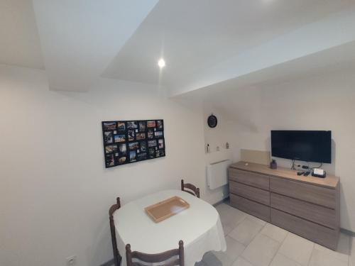 une pièce avec une table et une télévision sur un meuble dans l'établissement Maison de village, à Bassan