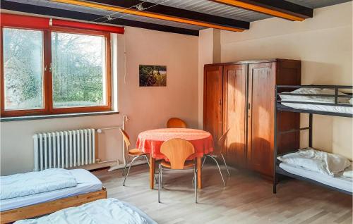 a room with a table and a bed and bunk beds at Amazing Home In Brüssow With Wifi in Brüssow