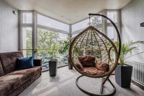 a room with a rattan swing in front of a window at Hotel CARO in Poznań