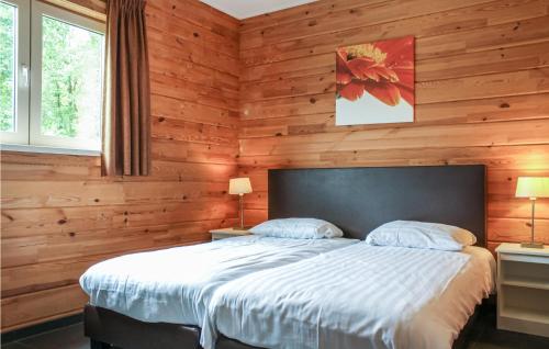 a bedroom with a large bed with wooden walls at Lovely Home In Heel With House Sea View in Heel