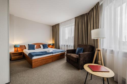 a hotel room with a bed and a chair at Hotel CARO in Poznań