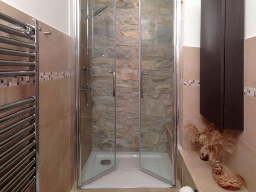La salle de bains est pourvue d'une douche avec une porte en verre. dans l'établissement Il Baglivo, à Agnone