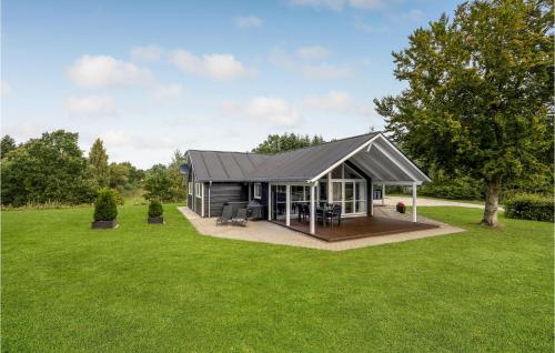 a small house with a grey roof on a green field at Lovely Home In Hobro With Wifi in Hobro