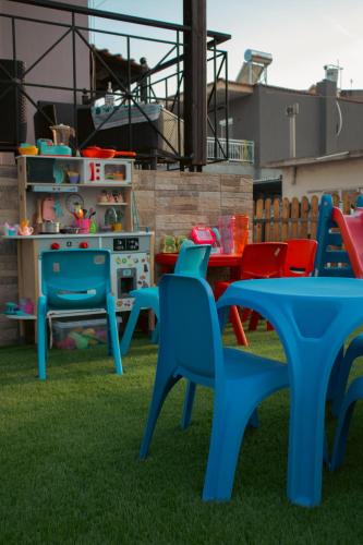 a group of blue tables and chairs on the grass at Emily Apartments 2 in Chrysoupolis