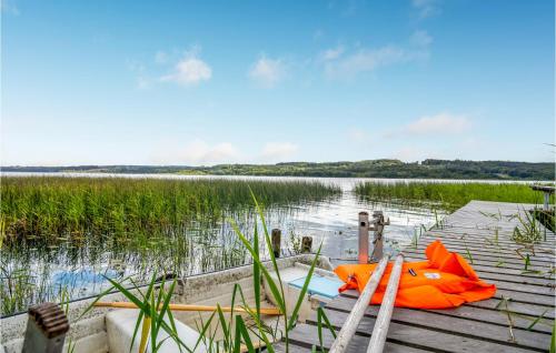 an orange kayak sitting on a dock in the water at Holiday Home Lindholmvej Ry Ix in Ry