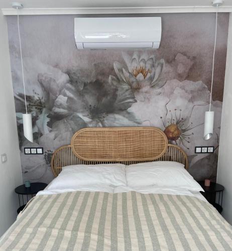 a bedroom with a bed with a flower mural on the wall at Bánhiday H31 Beach house in Balatonakarattya