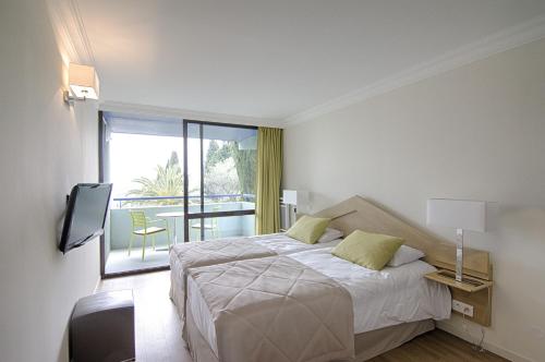 格拉斯的住宿－勒斯賽德雷斯阿克鄉村度假酒店，一间白色卧室,配有床和阳台
