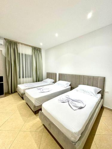 a bedroom with two beds and a window at Hotel Balili in Vlorë