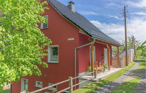 a red house with a porch on a street at Amazing Home In Pulsnitz With Kitchen in Pulsnitz