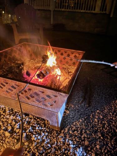 a fire pit with a person holding a torch at Bloom Victorian Bed & Breakfast in South Orange