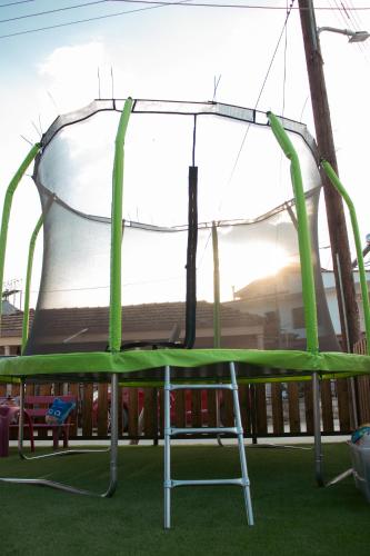 a swing set with green padding on a playground at Emily Apartments 2 in Chrysoupolis