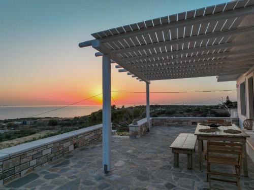 a patio with a table and a view of the ocean at ‘Sophie’s Villa’ in Naxos Chora