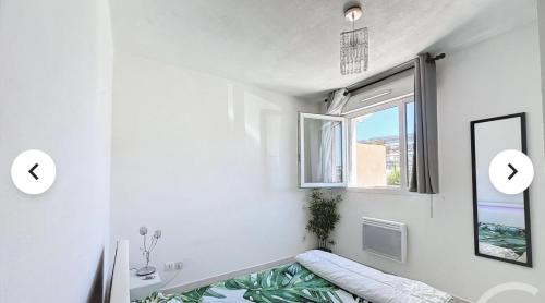 Cette chambre blanche dispose d'une fenêtre et d'un canapé. dans l'établissement appt 2 chambres, à Montpellier