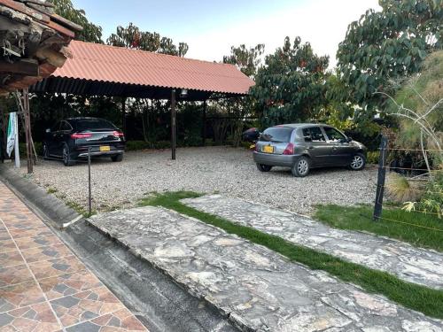 two cars parked in a gravel parking lot at Espléndida casa de campo in Tocancipá