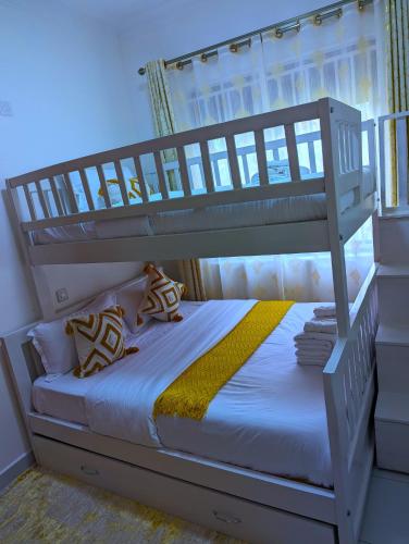 a bedroom with a bunk bed with a ladder at Shirleyz Cozy Haven - a delightful apt in Jinja City in Jinja