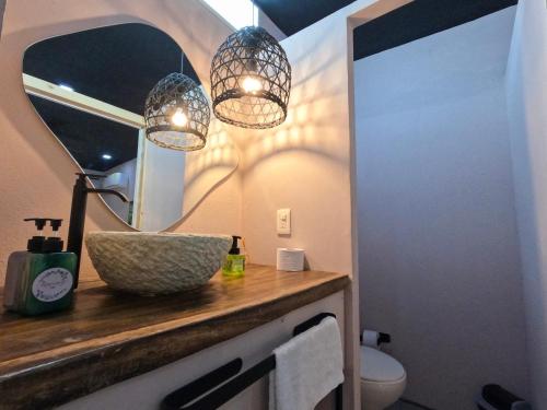 a bathroom with two pendant lights and a sink at Hotel Casa de Hadas in Minca