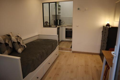 une petite chambre avec un lit et une cuisine dans l'établissement Maisonnette au porte des vignes, à Gradignan