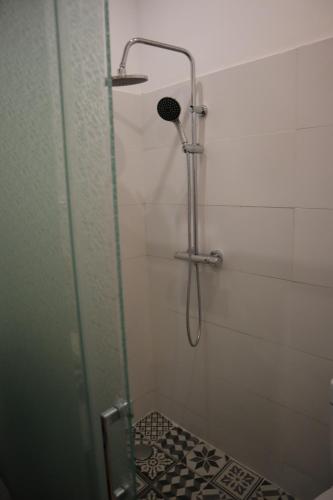 une douche dans une salle de bain avec une porte vitrée dans l'établissement Maisonnette au porte des vignes, à Gradignan