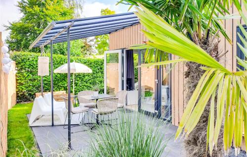 a patio with a table and chairs in a garden at Lovely Home In Heinkenszand With Wifi in Heinkensand