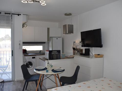 une cuisine avec une petite table et des chaises dans l'établissement Studio ★★★, Climatisé, Wifi, Proche Thermes et Commerces - FR-1-503-140, à Balaruc-les-Bains