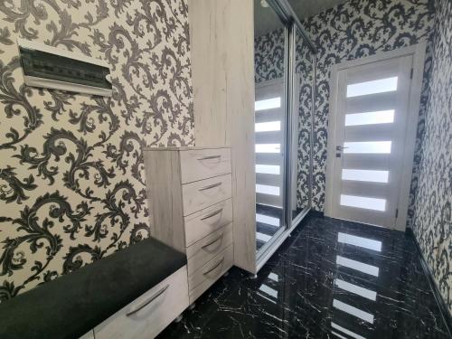 a bathroom with a black and white patterned wall at Testemiteanu 2 bedroom apartment air-conditioned in Chişinău