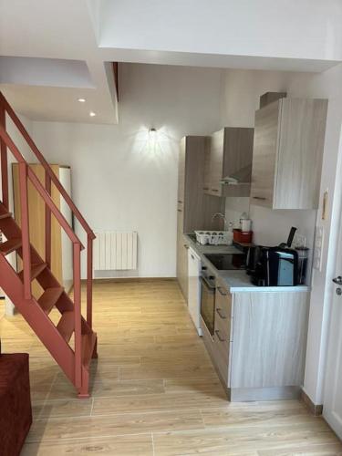 - une cuisine avec un comptoir et un escalier dans une pièce dans l'établissement Petite maison cosy en bord de Marne 2 lits en mezzanine, à Maisons-Alfort