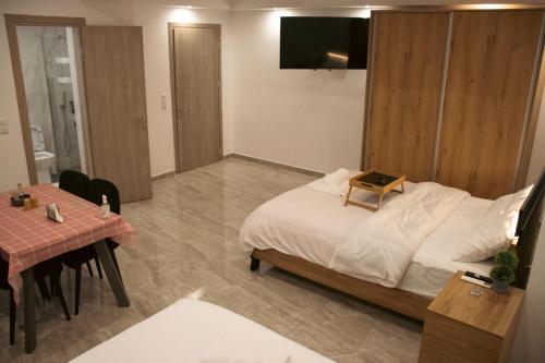 a bedroom with a bed and a table and a television at Emily Apartments 3 in Chrysoupolis