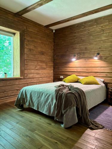 a bedroom with a bed with wooden walls and wooden floors at Lehtla Puhkekompleks in Austla