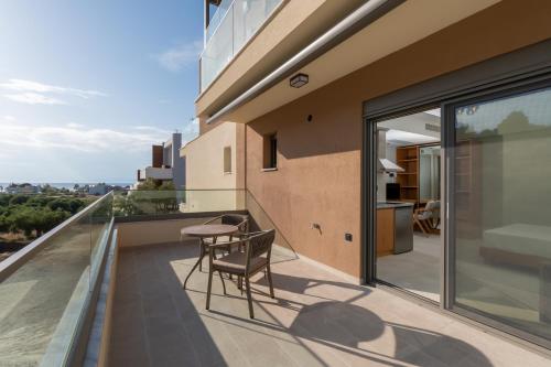 a balcony with a table and chair on top of a building at HP Family Suites in Neos Marmaras