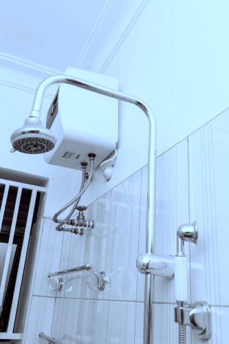 a shower with a light in a bathroom at Shirleyz Cozy Haven - a delightful apt in Jinja City in Jinja