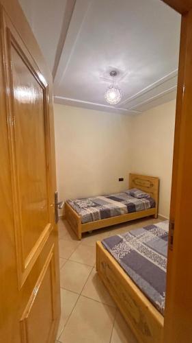 a room with two beds and an open door at Appartement saidia in Saidia 
