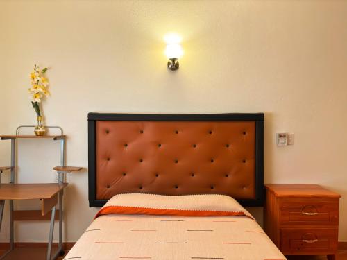 a bedroom with a bed and a light on the wall at Casa Elim-Oaxaca in Teotitlán del Valle