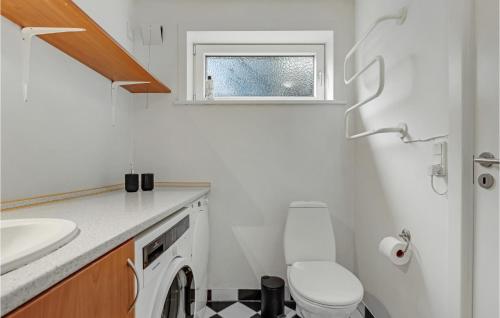 a white bathroom with a toilet and a sink at Holiday Home Højskolevej Kruså Iii in Rønsheved
