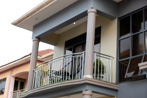 a balcony of a house with a dog on it at Shirleyz Cozy Haven - a delightful apt in Jinja City in Jinja