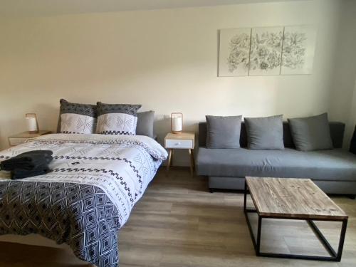 a living room with a bed and a couch at chez Odette Cypres de Provence in Esnoms-au-Val